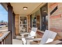 Inviting front porch with white Adirondack chairs, perfect for relaxing and enjoying the outdoors at 2045 Jamaica St, Aurora, CO 80010