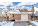 Brick ranch home with attached garage and snowy front yard at 7113 Depew Ct, Arvada, CO 80003