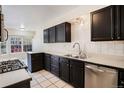 A full view of the kitchen showcasing the tiled countertops and black cabinets at 1566 S Syracuse St, Denver, CO 80231