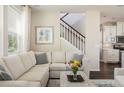 Comfortable living room showcasing a cozy sectional sofa, stylish decor, and stairway access to the upper level at 5451 W 73Rd Ave, Westminster, CO 80003