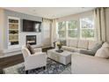 Inviting living room featuring a modern fireplace, plush seating, and bright natural light from large windows at 5451 W 73Rd Ave, Westminster, CO 80003