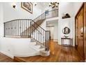 Grand two-story foyer featuring hardwood floors, iron staircase, and natural light at 5582 Twilight Way, Parker, CO 80134