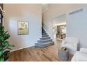 Inviting entryway with hardwood floors, a staircase, and a view into the dining area at 19357 E 40Th Ave, Denver, CO 80249