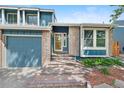Close up of the brick front entrance with blue siding and two car garage on a sunny day at 7226 S Eagles Nest Cir, Littleton, CO 80127