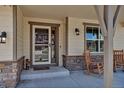 Cozy front porch with rocking chairs, decorative lights and a welcoming entrance at 4032 Donnington Cir, Castle Rock, CO 80104