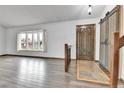 Welcoming entryway featuring wood-look floors, a bay window and a rustic barn door at 7796 S Marshall Ct, Littleton, CO 80128