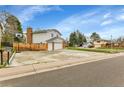 Two-story home featuring a two-car garage, basketball hoop, and fenced yard at 7796 S Marshall Ct, Littleton, CO 80128