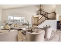 Bright and airy living room with a staircase, large window, and neutral decor at 1805 August Ln, Brighton, CO 80601