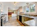 Open kitchen leading to a living room with a brick fireplace and new flooring at 1487 S Zeno Way, Aurora, CO 80017