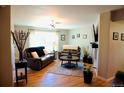 Inviting living room with wood floors, plenty of seating, and natural light from a large window at 3825 S Monaco Pkwy # 111, Denver, CO 80237