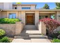 Close-up of the grand double-door entrance with brick pillars and well-maintained landscaping at 4800 E Cedar Ave, Denver, CO 80246