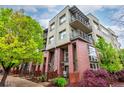 Contemporary condo building features private balconies, brick accents, and lush landscaping at 7700 E 29Th Ave # 405, Denver, CO 80238