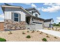 Charming two-story home featuring stone accents, gray siding and a two-car garage at 4451 Soapberry Pl, Castle Rock, CO 80108