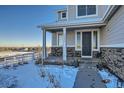 Inviting front porch with stonework and a dark brown front door at 9880 E 160Th Pl, Brighton, CO 80602