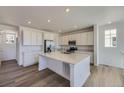 Modern kitchen features stainless steel appliances and a center island with quartz countertops at 8858 Waterleaf Ln, Littleton, CO 80125
