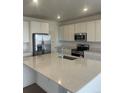 Bright kitchen with stainless steel appliances, large island, and white cabinets at 8858 Waterleaf Ln, Littleton, CO 80125