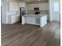 Open-concept kitchen boasts stainless steel appliances and a large island with seating at 8858 Waterleaf Ln, Littleton, CO 80125