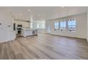 Open concept living space with large windows, hardwood floors, and a kitchen island at 8858 Waterleaf Ln, Littleton, CO 80125