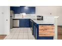 Stylish kitchen featuring navy cabinetry, stainless steel appliances, and white subway tile backsplash at 70 N Grant St # 10, Denver, CO 80203
