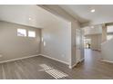Bright living room with gray vinyl flooring, large windows, and neutral paint at 18358 Field Mint Pt, Parker, CO 80134