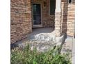 Covered front porch with stone facade and landscaping at 13349 Krameria St, Thornton, CO 80602