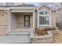 Charming front entrance with brick accents and a well-maintained walkway, providing curb appeal at 11076 W Dumbarton Cir, Littleton, CO 80127