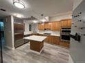 Well-equipped kitchen featuring an island, wooden cabinets, modern appliances, and bright countertops at 1350 Lawrence St # 2F, Denver, CO 80204