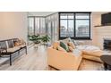 Living room featuring a plush sectional sofa, bright windows, and sleek flooring at 1350 Lawrence St # 2F, Denver, CO 80204
