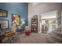 Inviting living room with blue accent wall and an open view of the stairs and kitchen at 9200 W Indore Dr, Littleton, CO 80128