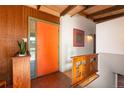 Bright entryway with brick flooring, wood accents, and an orange front door for a pop of color and mid-century flair at 5450 Mohawk Rd, Littleton, CO 80123