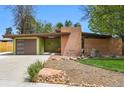 Striking mid-century modern home showcasing a unique design, attached garage, and attractive landscaping at 5450 Mohawk Rd, Littleton, CO 80123