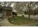 This home features a well-manicured lawn with budding plants and a brick and vinyl exterior at 3091 S Holly Pl, Denver, CO 80222