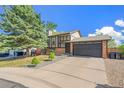 Charming two-story home features a brick facade, well-maintained lawn, and an attached two-car garage at 9605 Orangewood Dr, Thornton, CO 80260