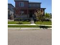 Charming two-story home featuring a covered front porch and well-manicured lawn at 17822 E 107Th Pl, Commerce City, CO 80022