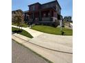 Beautiful two-story home with a covered porch, landscaped yard and a 'For Sale' sign at 17822 E 107Th Pl, Commerce City, CO 80022