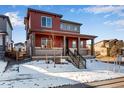 Attractive two-story house with a covered porch and well-kept landscaping, all set against a clear, sunny sky at 17822 E 107Th Pl, Commerce City, CO 80022