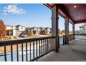 Inviting porch with sturdy columns and railings, offering a pleasant neighborhood view on a sunny day at 17822 E 107Th Pl, Commerce City, CO 80022