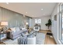 Bright living room with modern decor, wood floors, elegant gray sofa, and a decorative accent wall at 921 Meade St, Denver, CO 80204