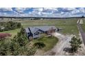 Aerial view of home with gray roof, siding, green yard, shed and gravel driveway with beautiful views of the meadow at 2996 Savage Rd, Elizabeth, CO 80107