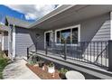 Inviting covered front porch with black metal railing and decorative potted plants at 2996 Savage Rd, Elizabeth, CO 80107