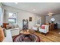 Spacious living room with hardwood floors, built-in window seat, and access to the dining area at 1655 S Lowell Blvd, Denver, CO 80219