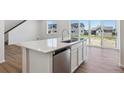Kitchen island featuring a stainless steel dishwasher, sink and a modern faucet at 18961 E 96Th Pl, Commerce City, CO 80022