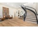 Bright foyer features a curved staircase, light wood floors, and an indoor fountain feature at 12963 Silver Elk Ln, Littleton, CO 80127