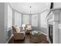 Cozy living room featuring a fireplace, beautiful wood floors, and large windows with plantation shutters at 16376 Stonefeld Pl, Parker, CO 80134