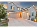 Attractive three car garage with gray siding, green shutters, and enhanced outdoor lighting at 17335 W 94Th Ave, Arvada, CO 80007