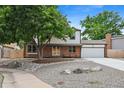 Attractive two-story home with a manicured front yard, mature tree, and an attached two-car garage at 10378 W Weaver Ave, Littleton, CO 80127