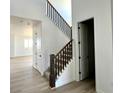 Bright entryway featuring wood-look floors and a staircase with dark wood railing at 25343 E Warren Pl, Aurora, CO 80018