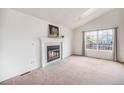 Bright living room featuring a cozy fireplace, neutral walls, and a large window at 12632 James Ct, Broomfield, CO 80020