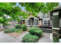 Charming townhome entrance with covered porch, stone accents, and well-maintained landscaping at 7140 Simms St # 102, Arvada, CO 80004