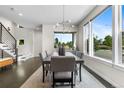 Bright dining room with large windows, modern lighting, and a view of the staircase at 5101 Quitman St, Denver, CO 80212